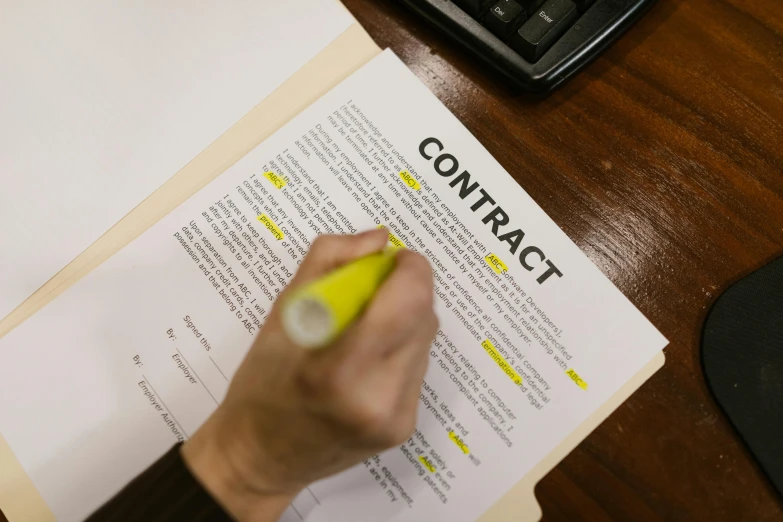 a hand holding a pen and writing on a paper