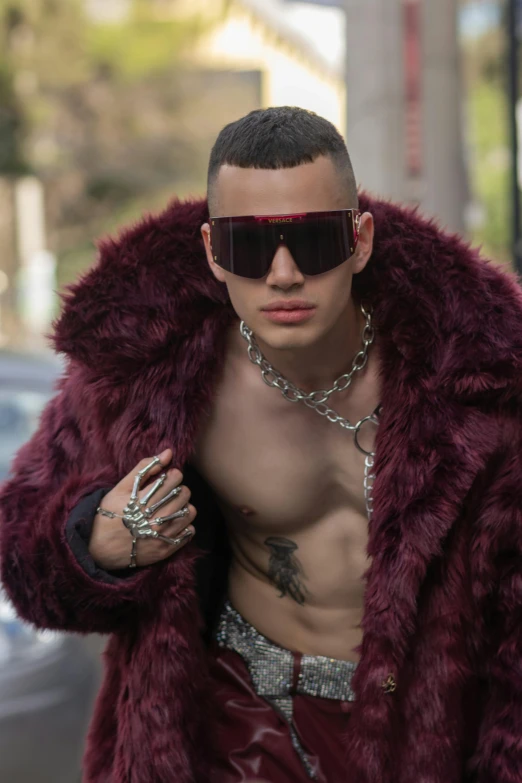 a shirtless male in sunglasses and a fur jacket