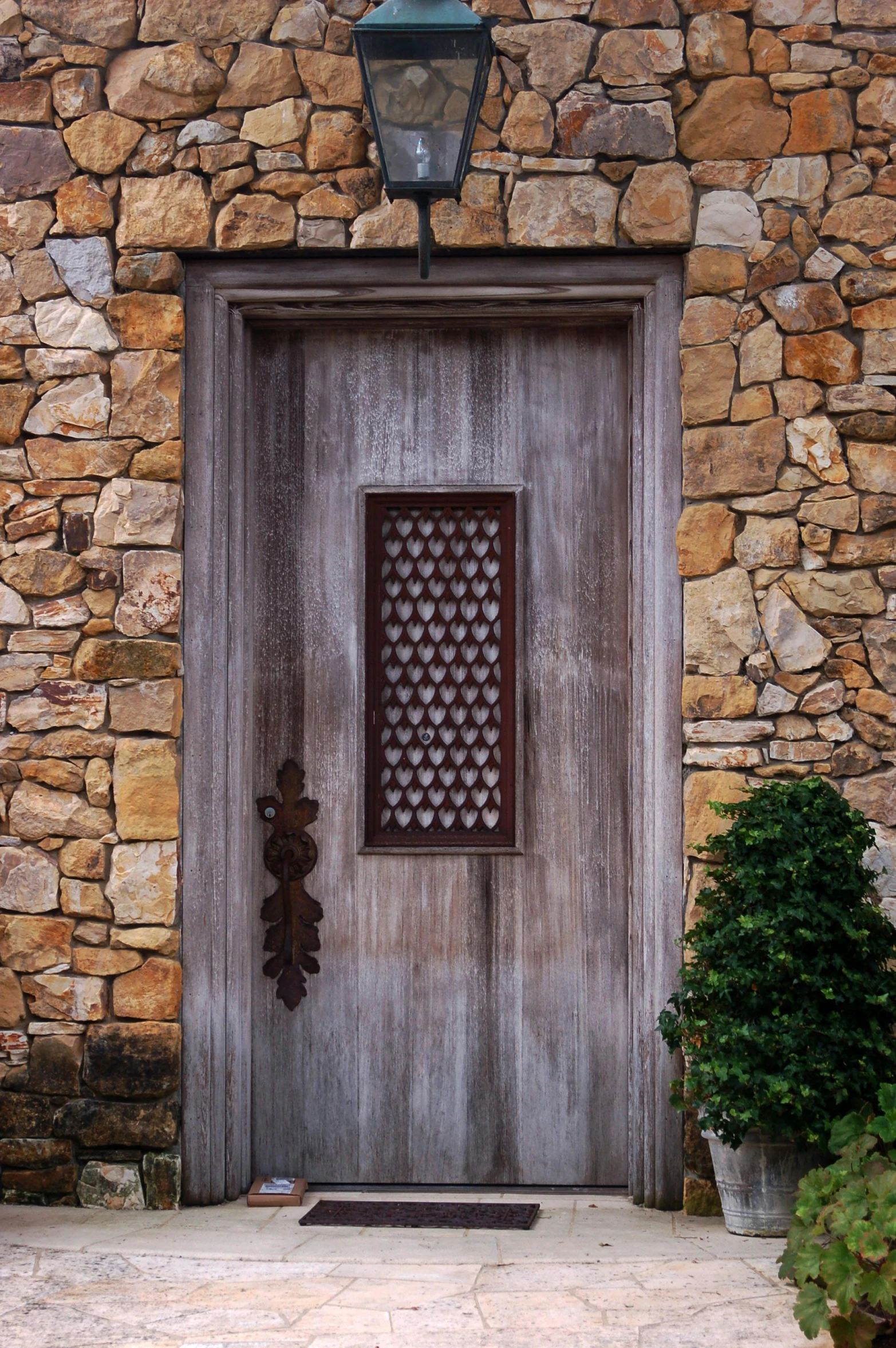 the doorway is made of stone, and has a decorative door panel