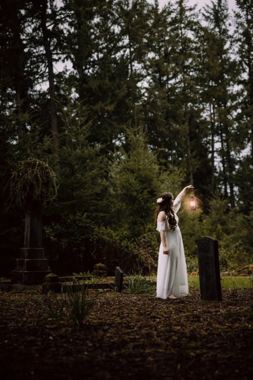 two women stand together in a wooded area