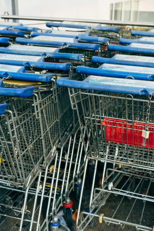 several shopping carts with various blue and red items on them