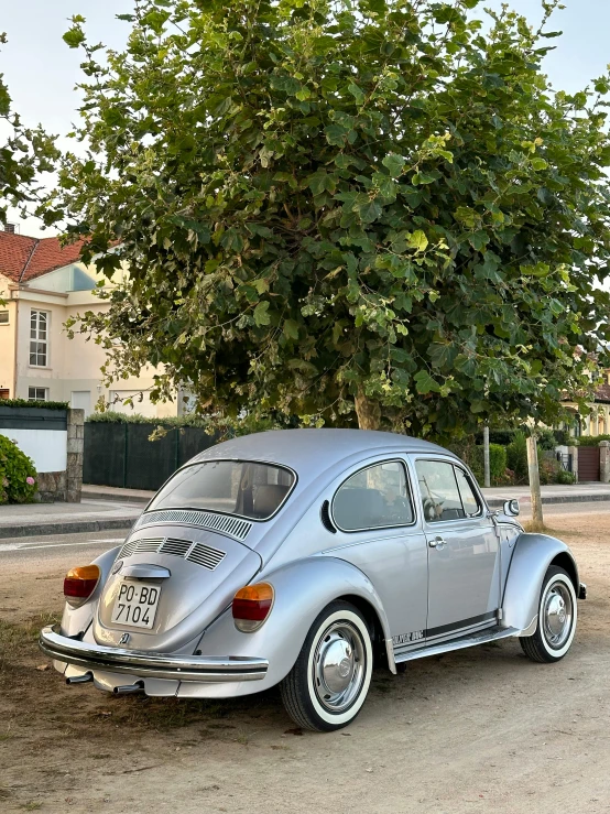 this silver volkswagen is sitting on the side of the road