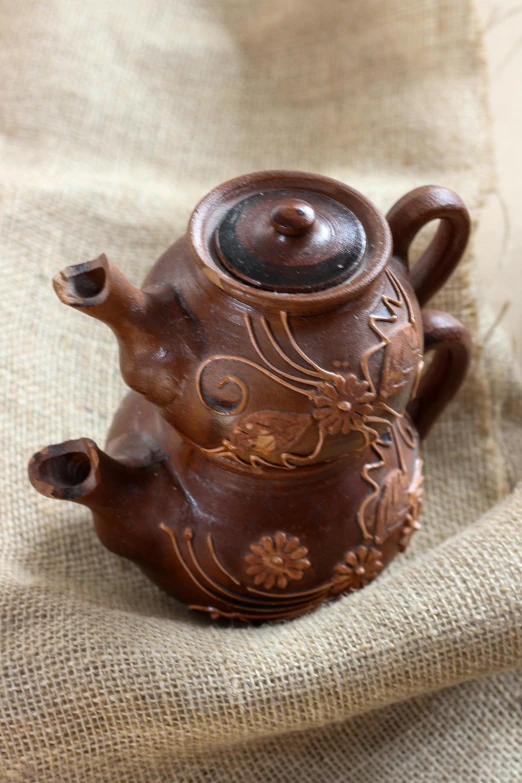 an antique tea pot decorated with a design