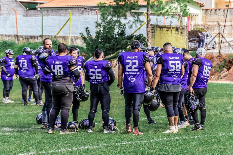 a team of people in a field with their backs turned towards the camera