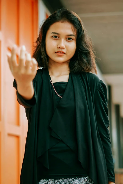 young woman in black jacket posing for a po