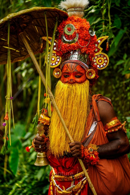 man in costume dressed up and holding a stick