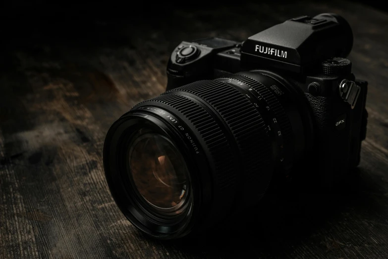 a camera with a lens attached is sitting on a wooden table