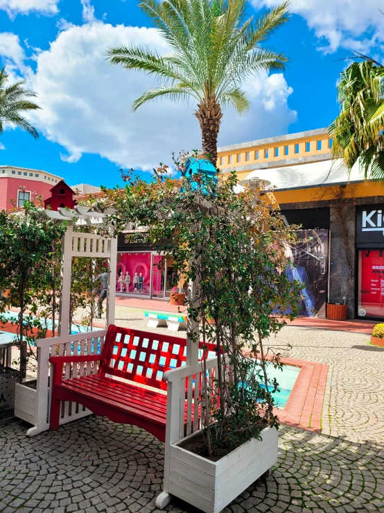 red bench with planters and trees in the front