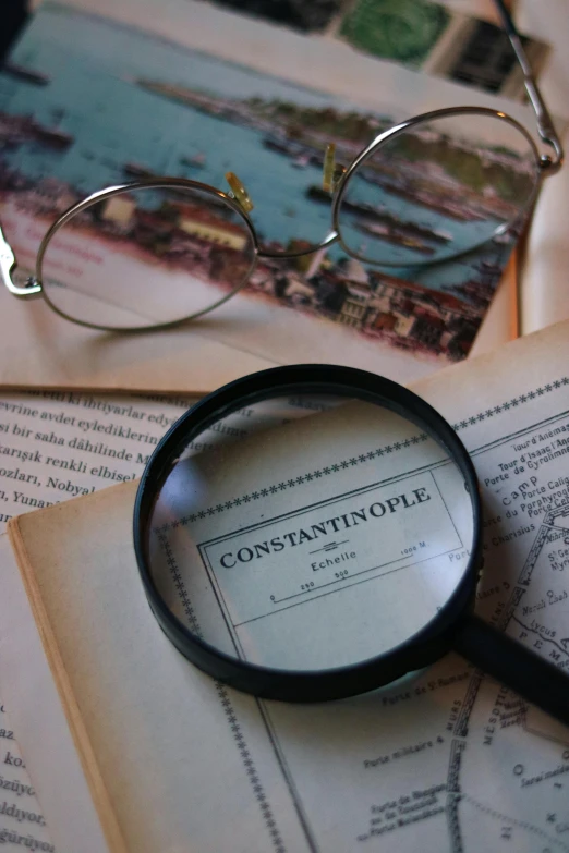an antique magnifying glass sits on a map of the countryside