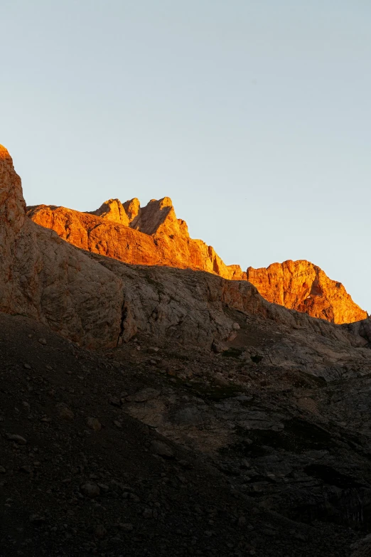 a group of hills with the sun setting