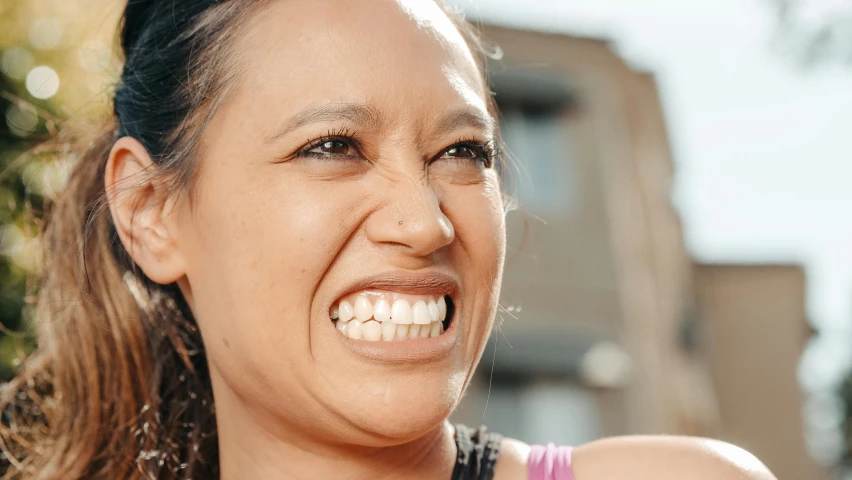 a woman smiles while smiling at the camera