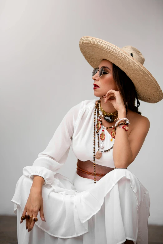 woman wearing dress and big hat sitting down