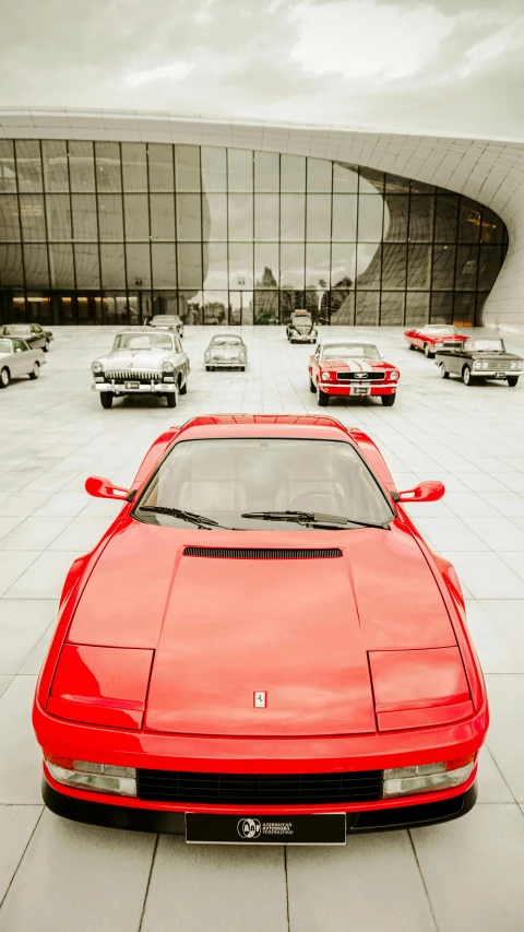 a red ferrari sports car parked next to a wall