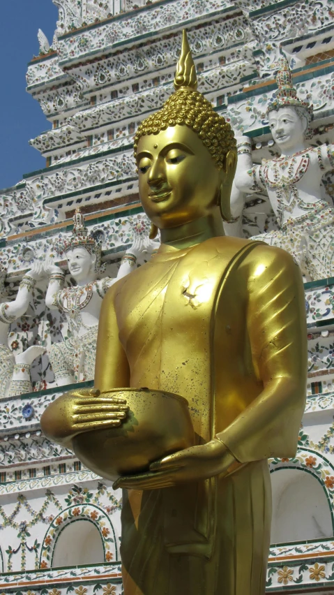 a statue stands near a tall white building