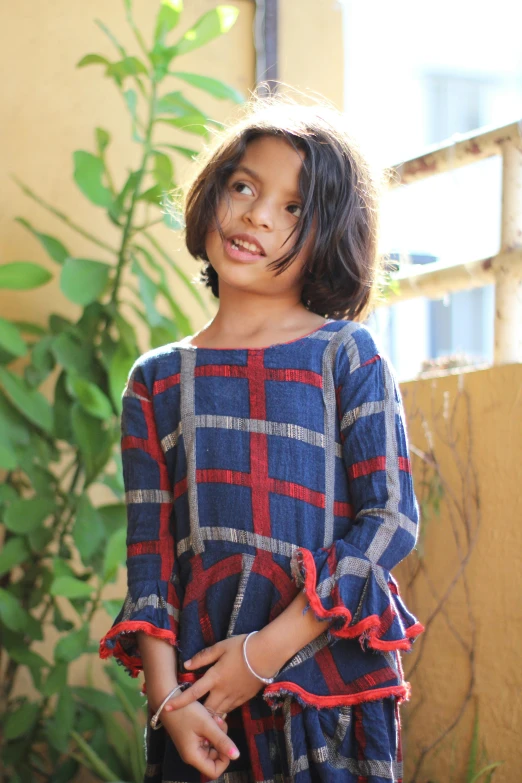 a little girl wearing a blue and red dress