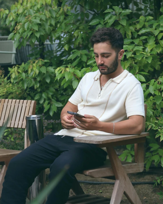 a man sitting down using his cell phone