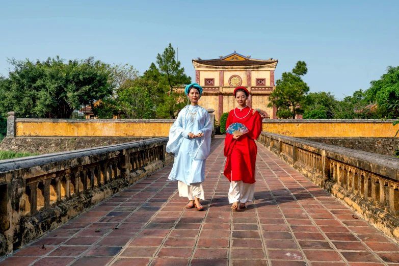 two women walking across an old bridge