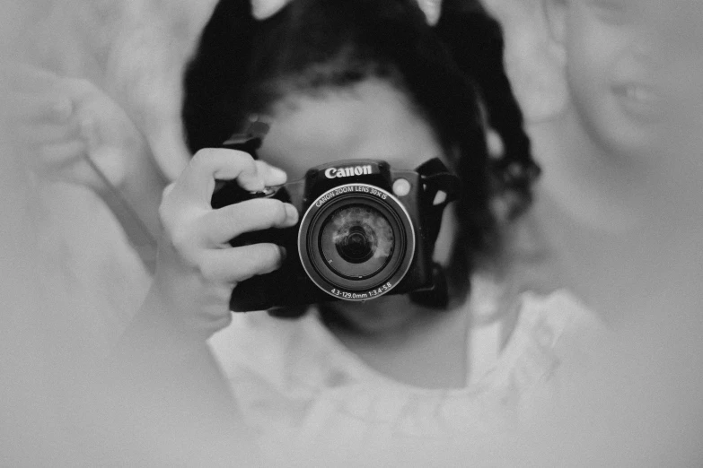 a person holding a camera and posing in front of them