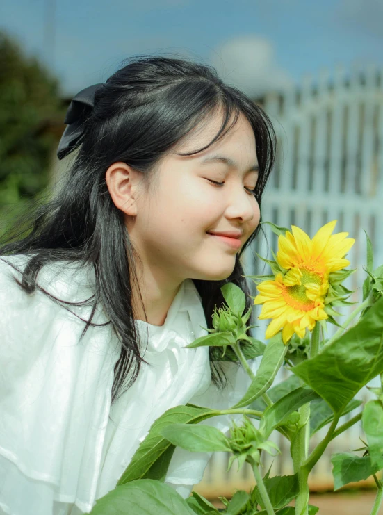 a girl with a bow near some sunflowers