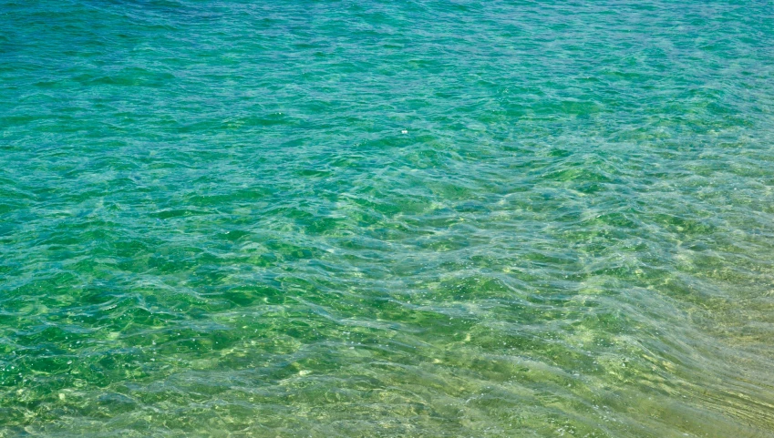 a boat floating on top of a calm blue ocean