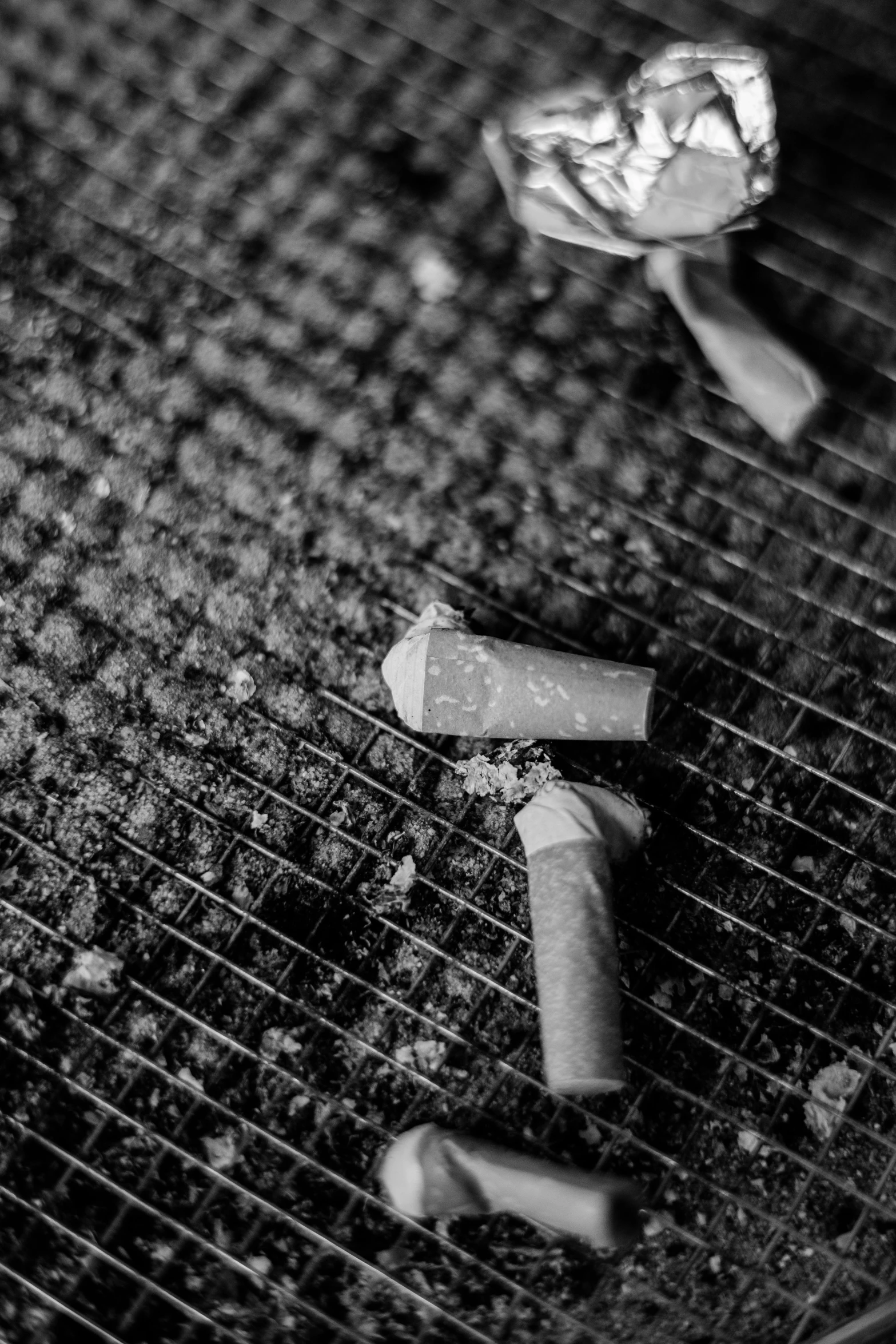 an empty metal grill pan with two cigarettes