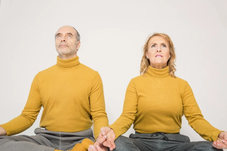 two people sitting on the ground in yoga gear with their heads open