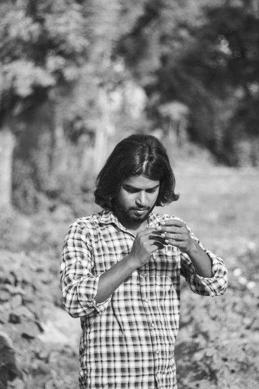 a man standing in the field, holding soing