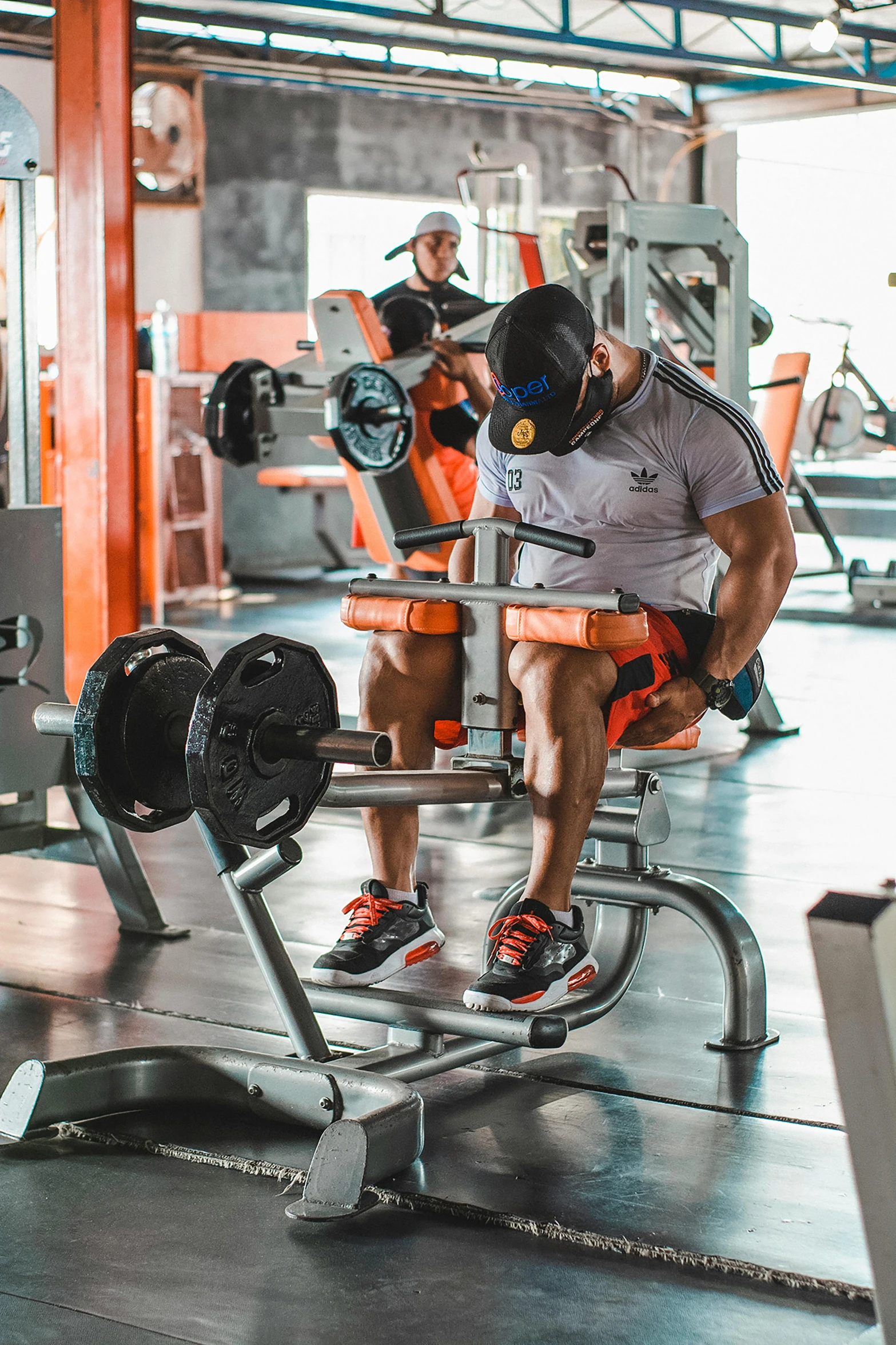 two men working out in the gym on weight machines