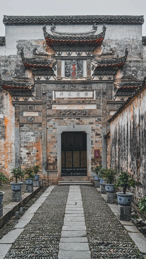 an old building with plant pots on the side