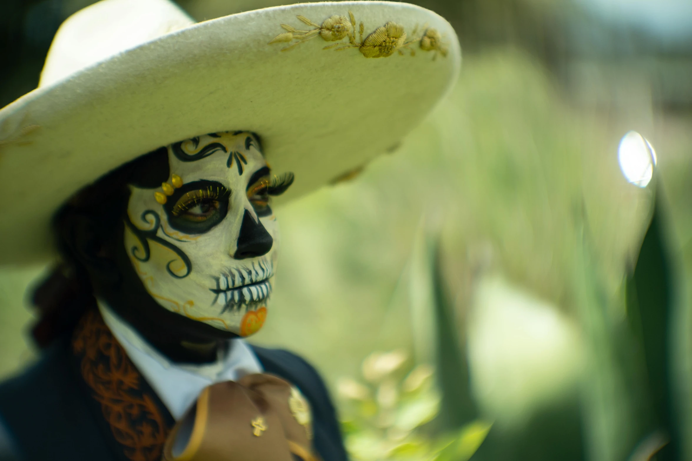 a skeleton with white makeup in an old fashion cowboy hat