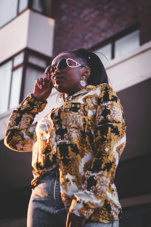 a woman wearing a patterned jacket and sunglasses