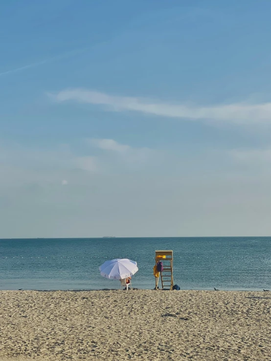 chairs and an umbrella on a beach in the sand