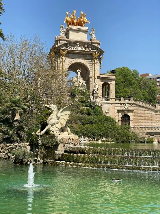 a fountain with a statue on it sits in front of a building