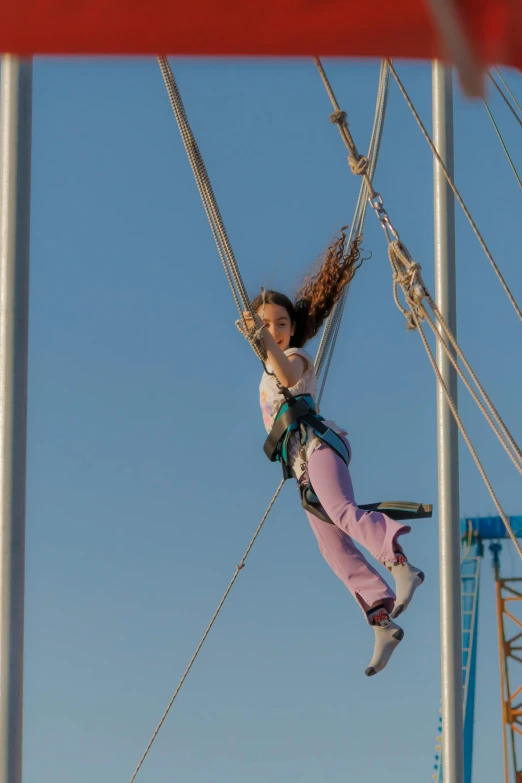 a girl climbing down on rope and holding onto soing