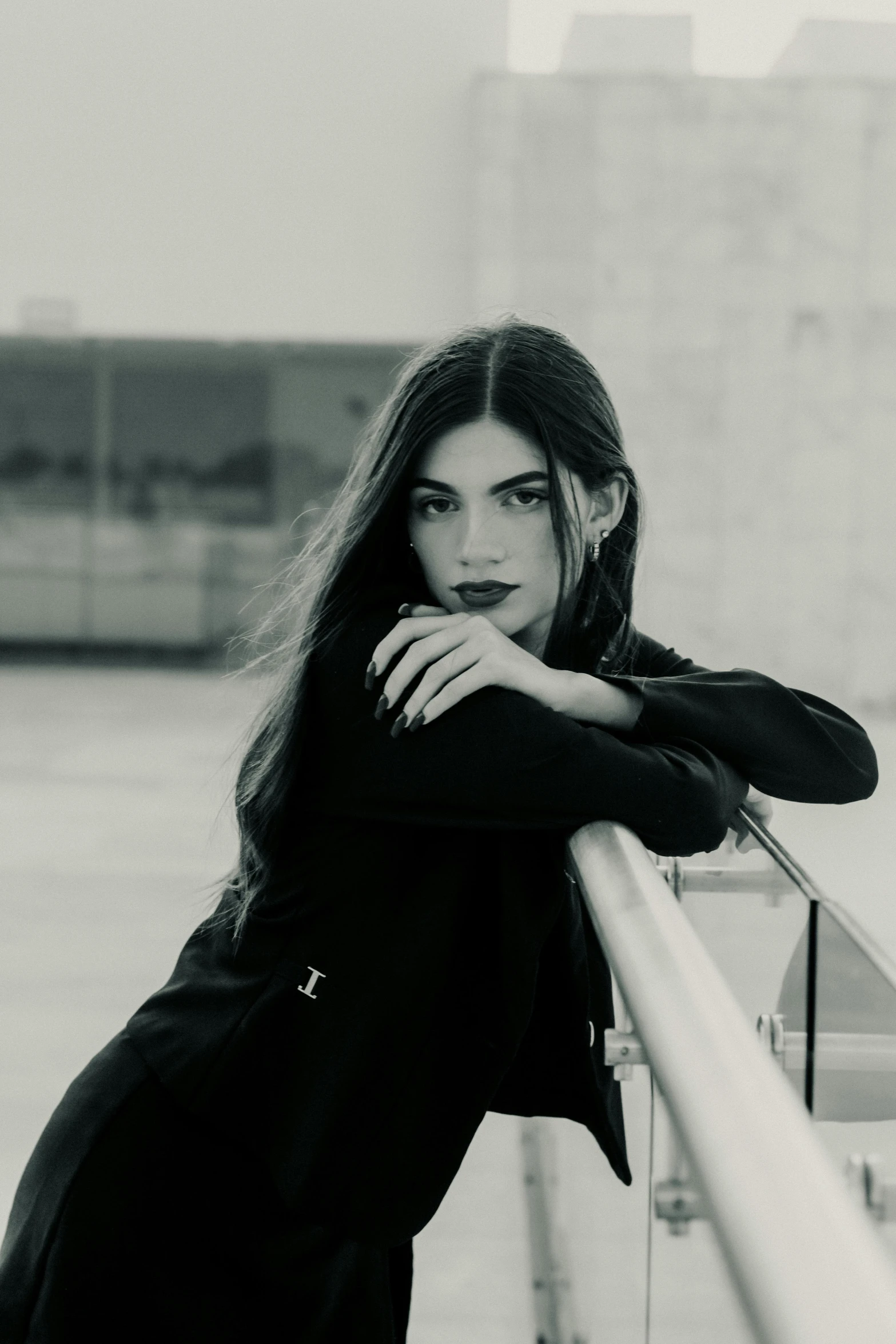 a woman leans over a rail near a city