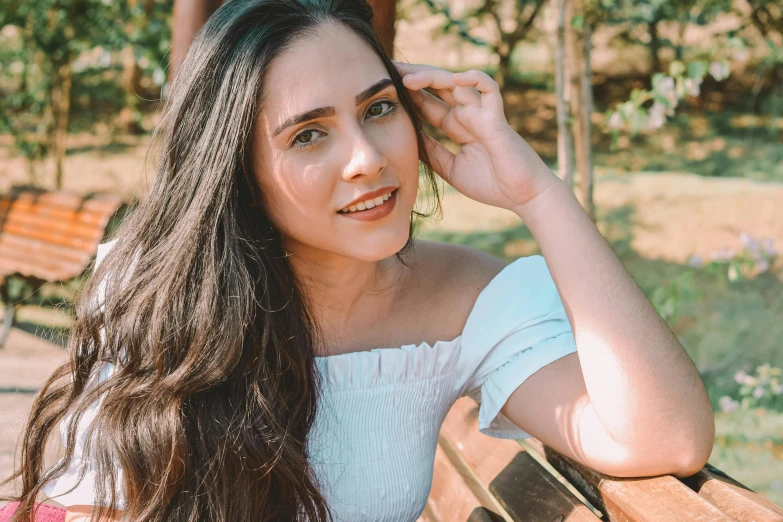 a young woman sitting on top of a wooden bench