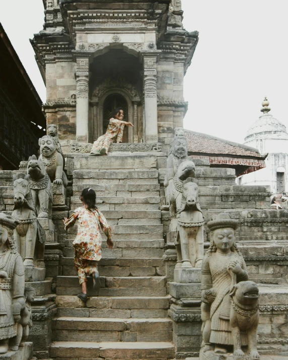 woman climbing stairs in front of statued structures