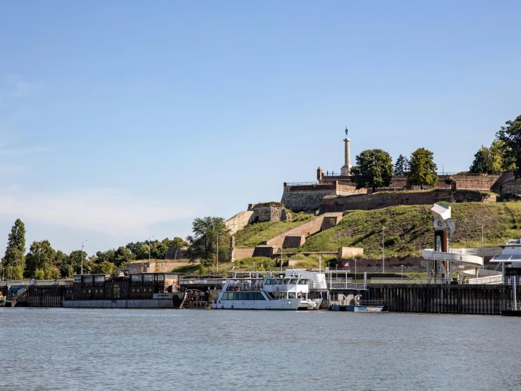 boats are docked next to an old iron fort on a hill