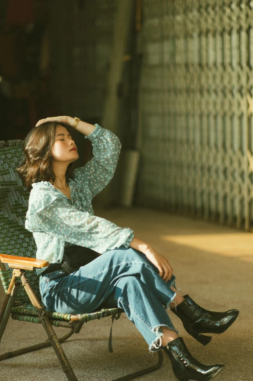 woman sitting on folding chair outside with her head in her hand