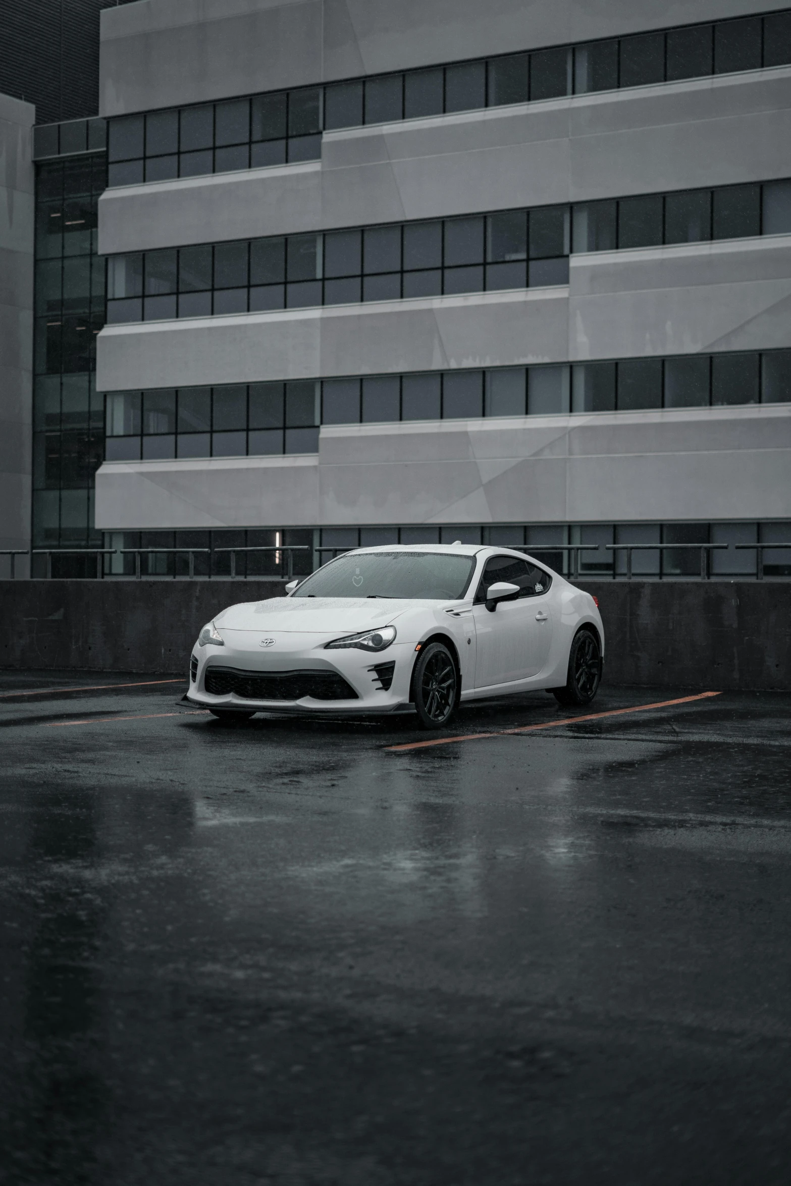 the white car is parked in front of a very tall building