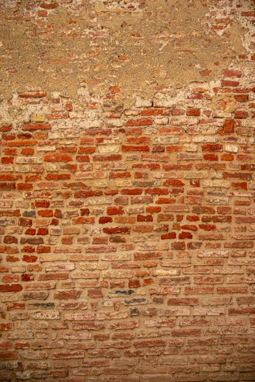 an old wall made out of bricks, with a faded spot