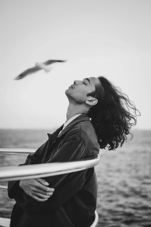 a woman looks up and watches a bird fly by