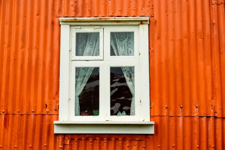 there is a window with glass in the orange building