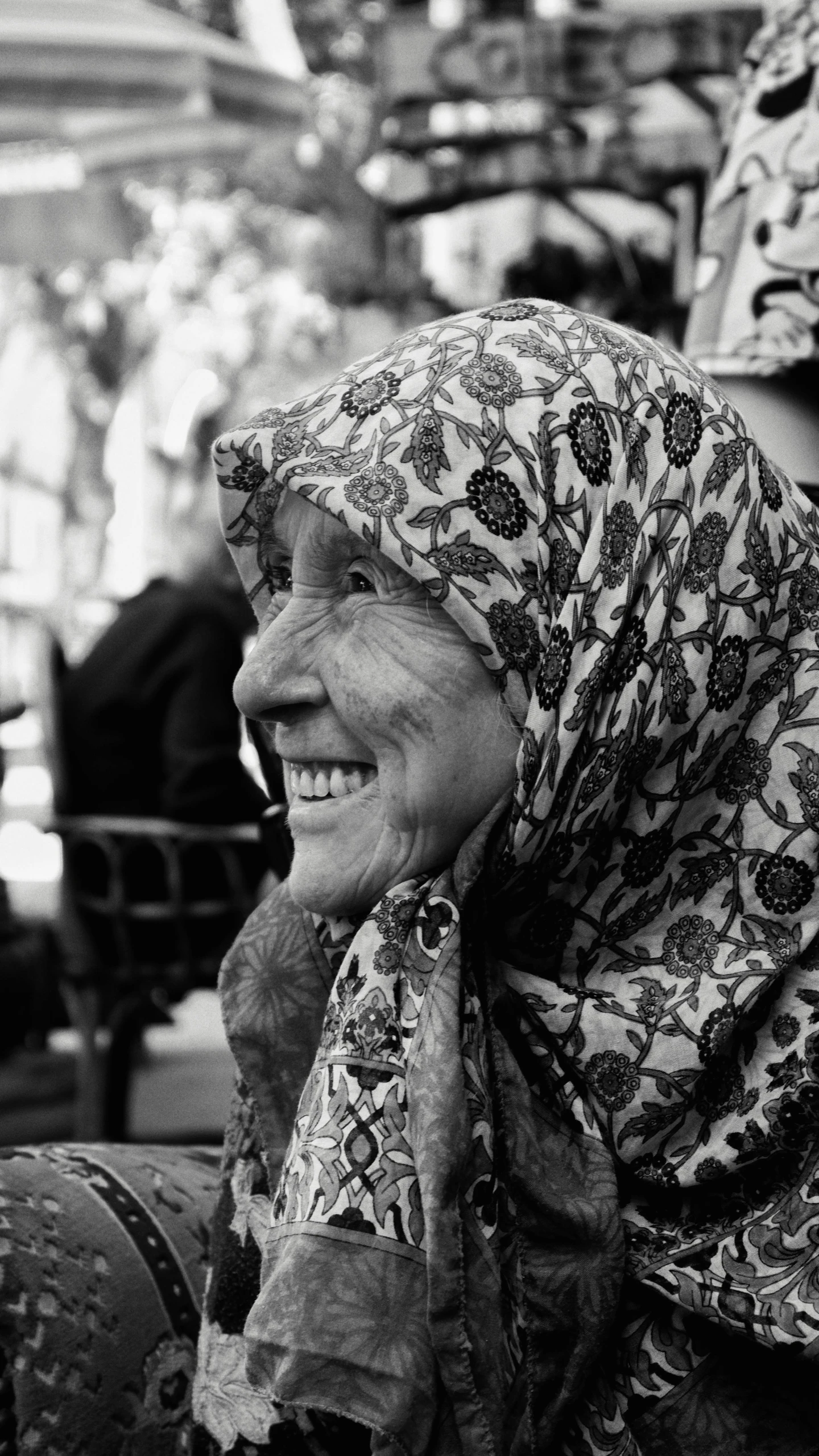 a smiling woman wearing a head scarf