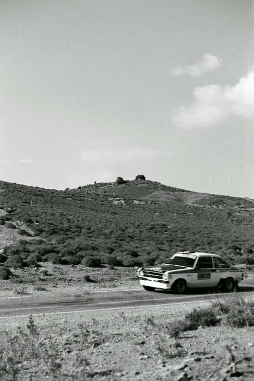 a truck in a desert area with a mountain in the background