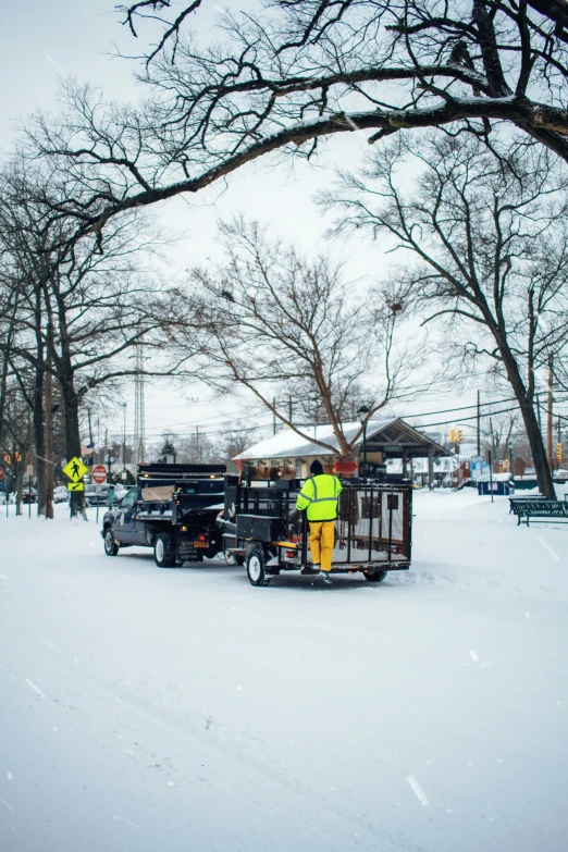 two men standing next to a truck on snow covered ground