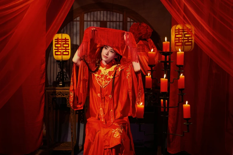 a woman is posing in a red dress and holding a large red curtain over her head
