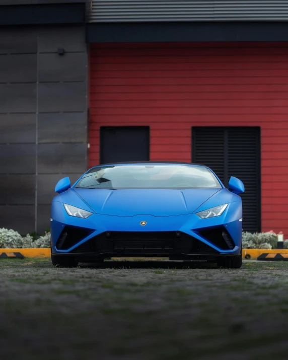 a blue sports car parked in front of a building