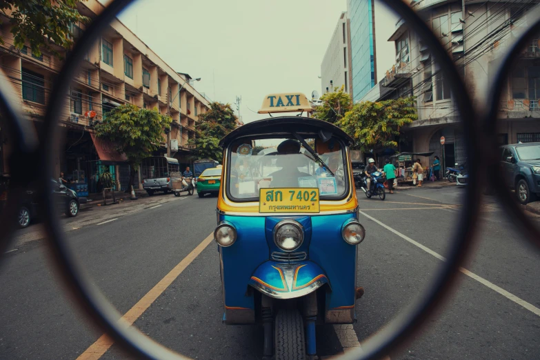 the side view mirror is reflecting a street scene