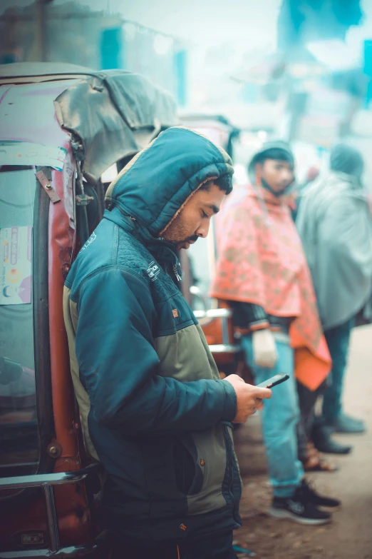 the man is looking at his phone while standing in the street